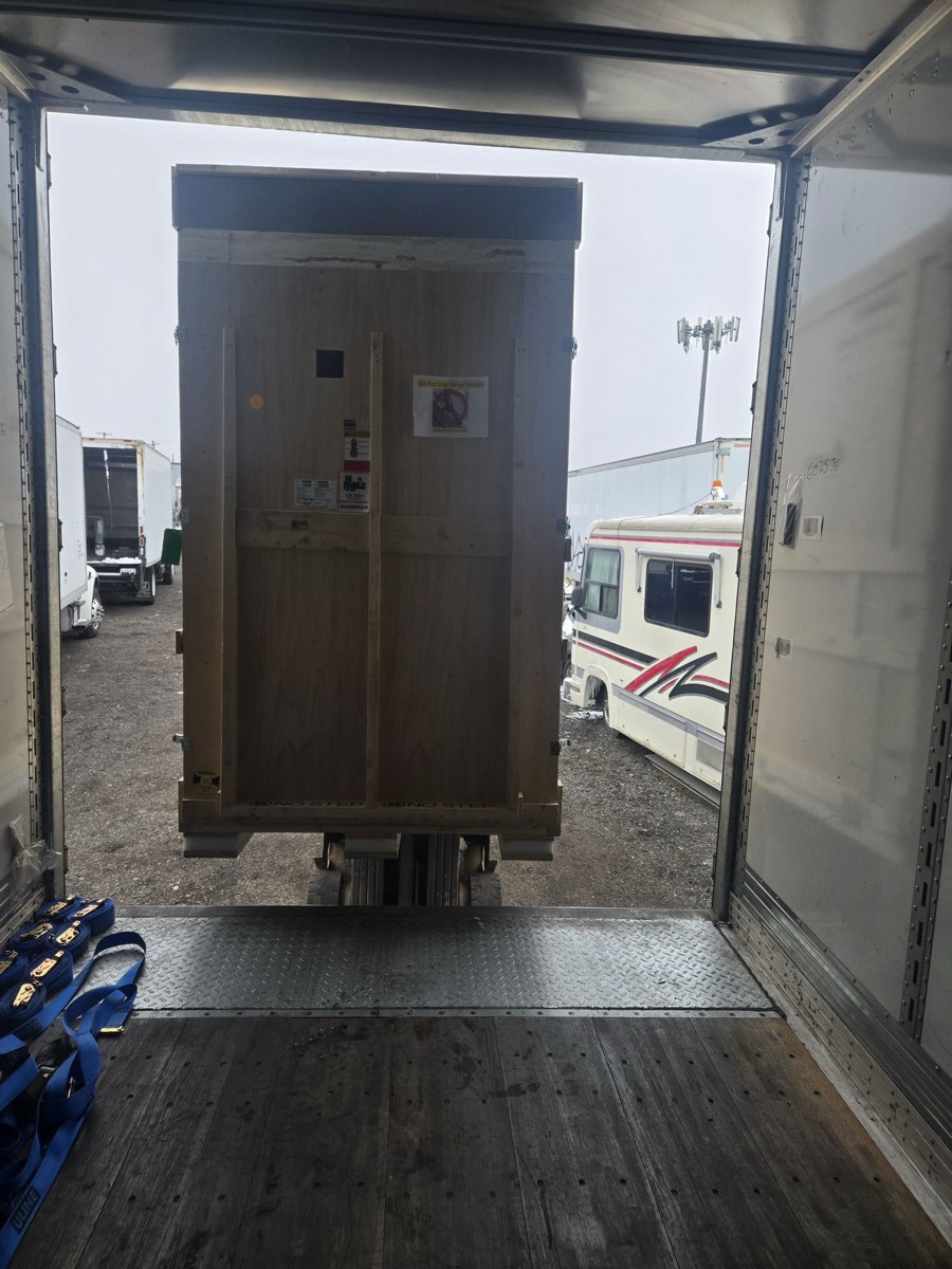 View from inside truck trailer showing shipping crate ready for pickup in Denver