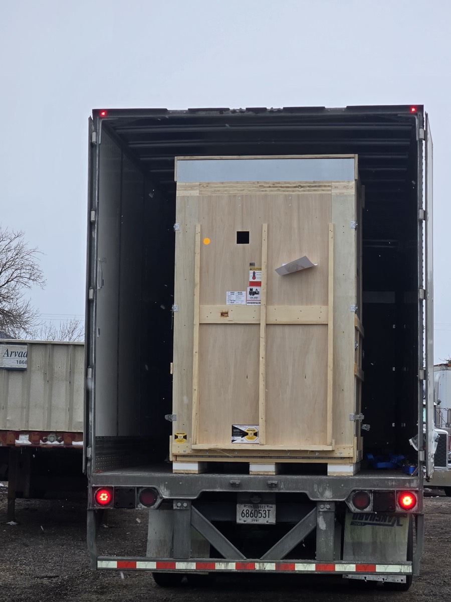 Large shipping crate on semi-trailer ready for removal in Denver